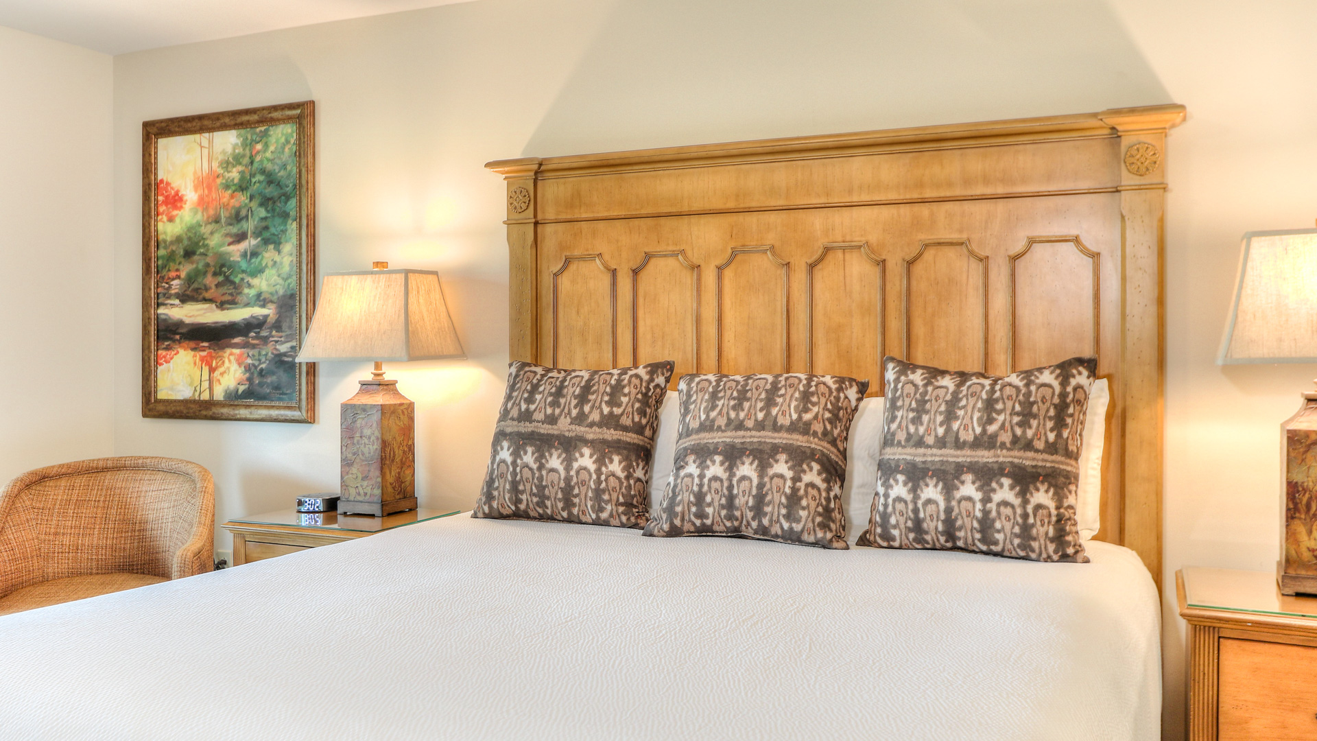 a bed with pillows and a lamp on a nightstand