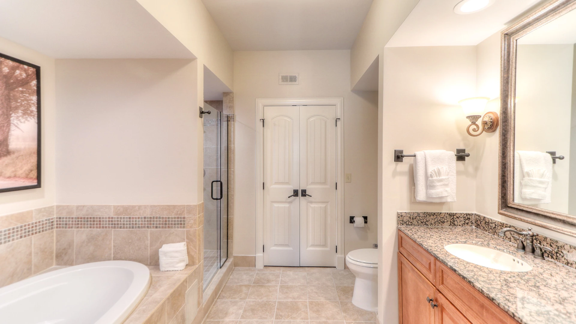 A clean and well-appointed bathroom with a bathtub, shower, toilet, and sink.