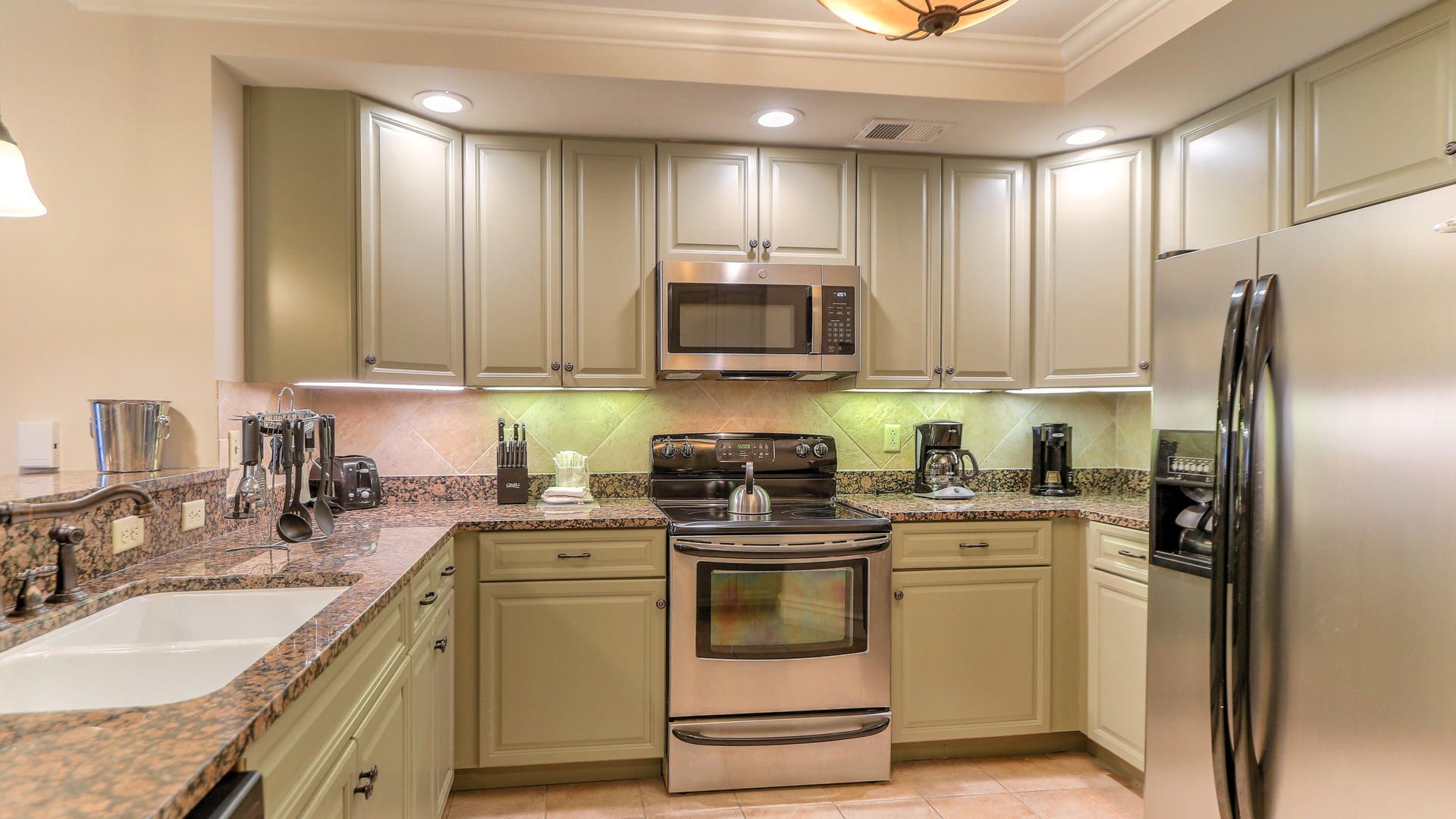a kitchen with white cabinets and granite counter tops