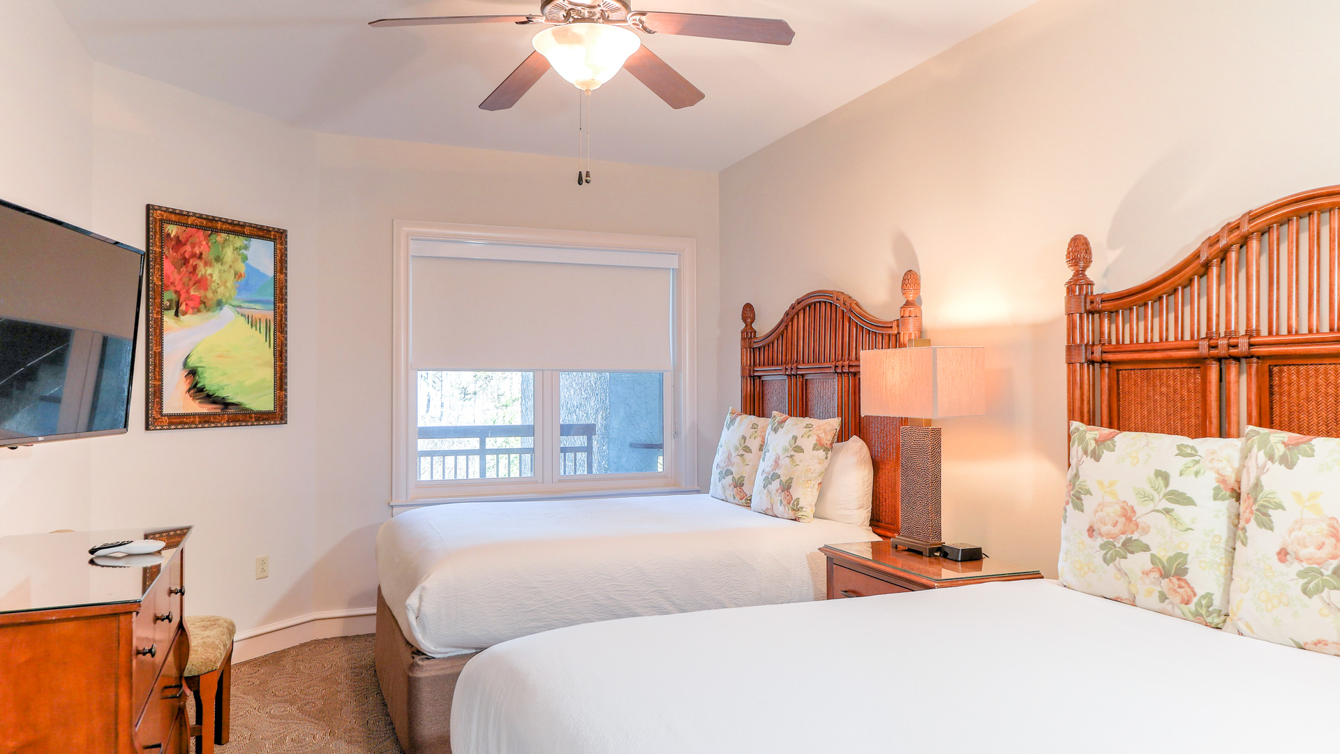 a room with two beds and a ceiling fan