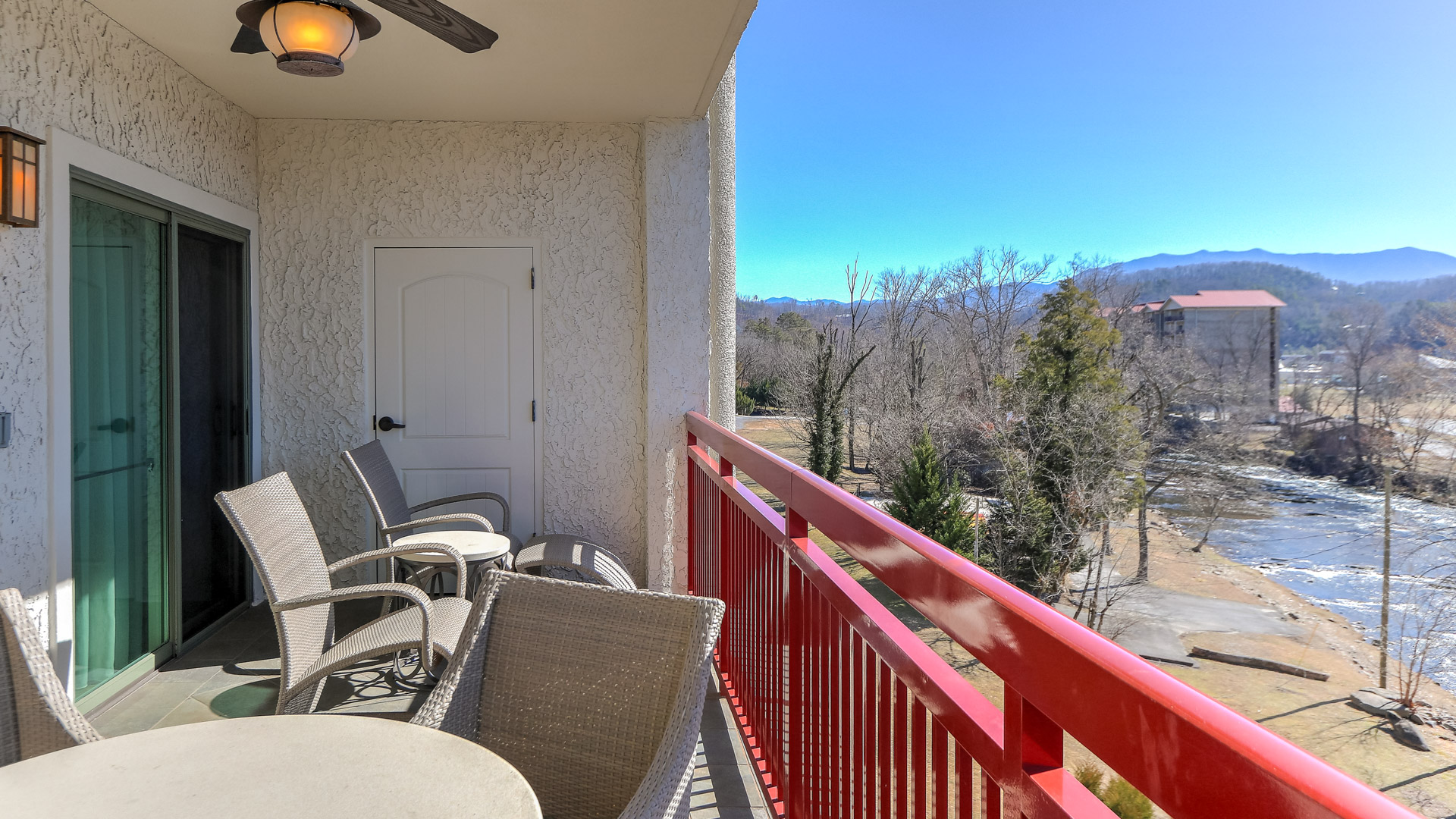 a balcony with chairs and a red railing