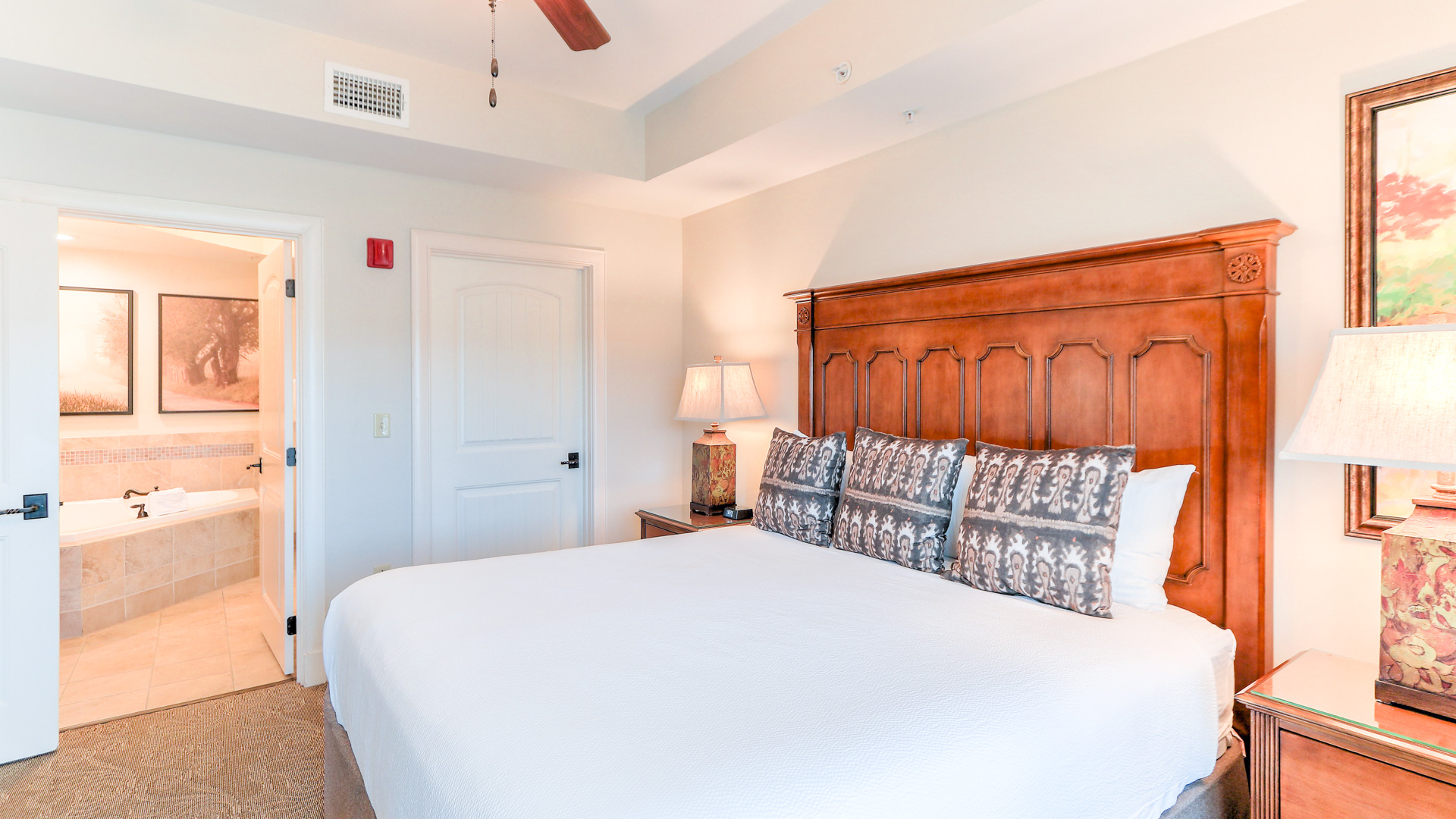 a bed with pillows and a fan in a room