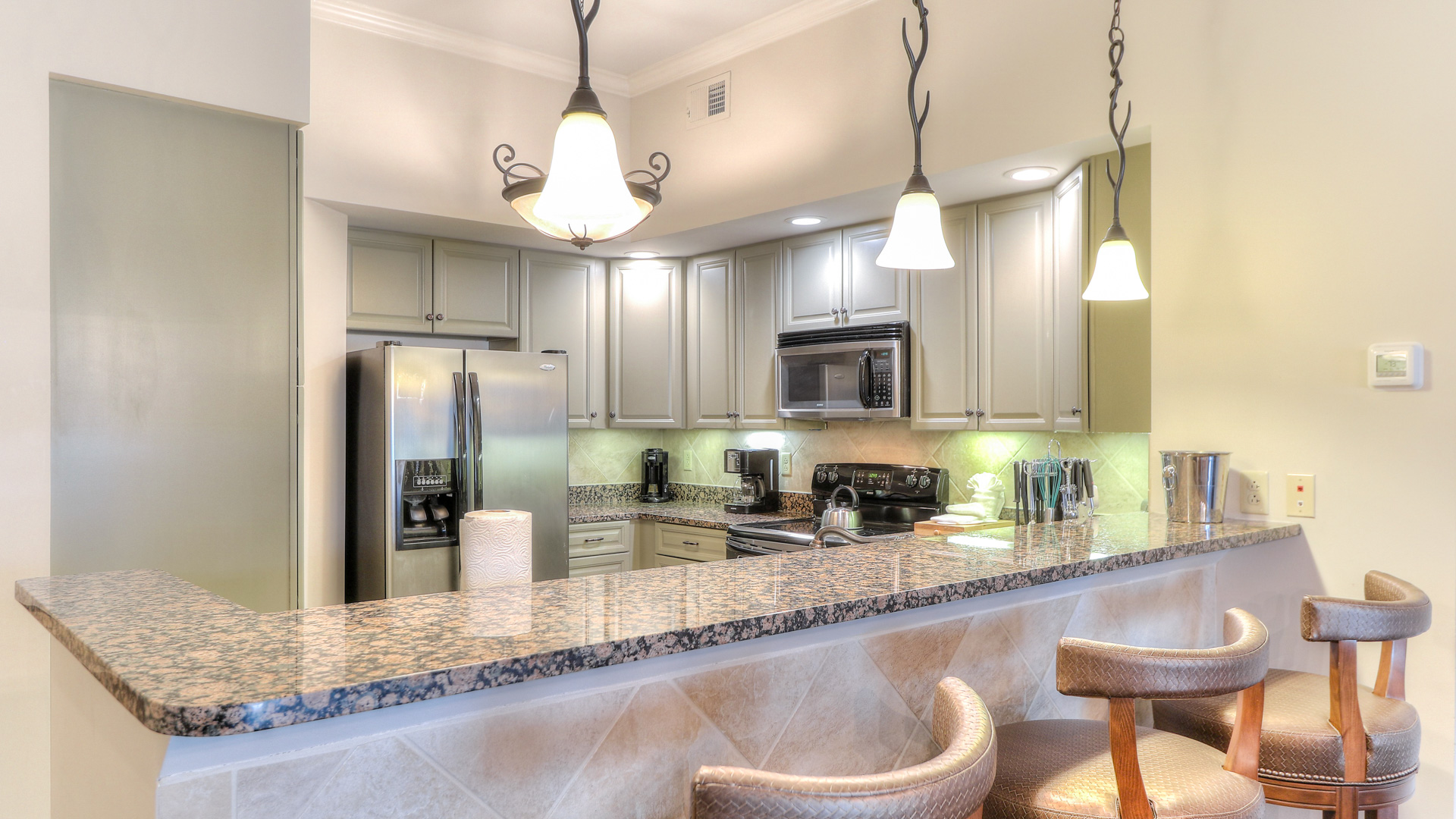 a kitchen with a marble counter top and a refrigerator