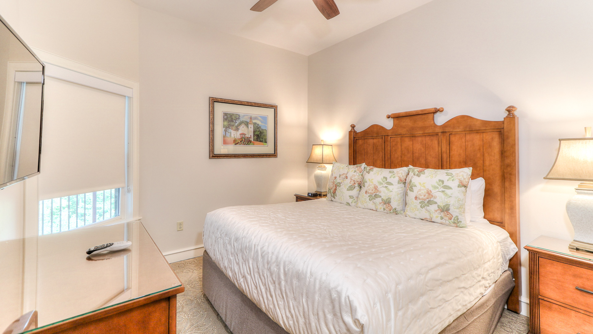 a bed with a wooden headboard and a fan in a room