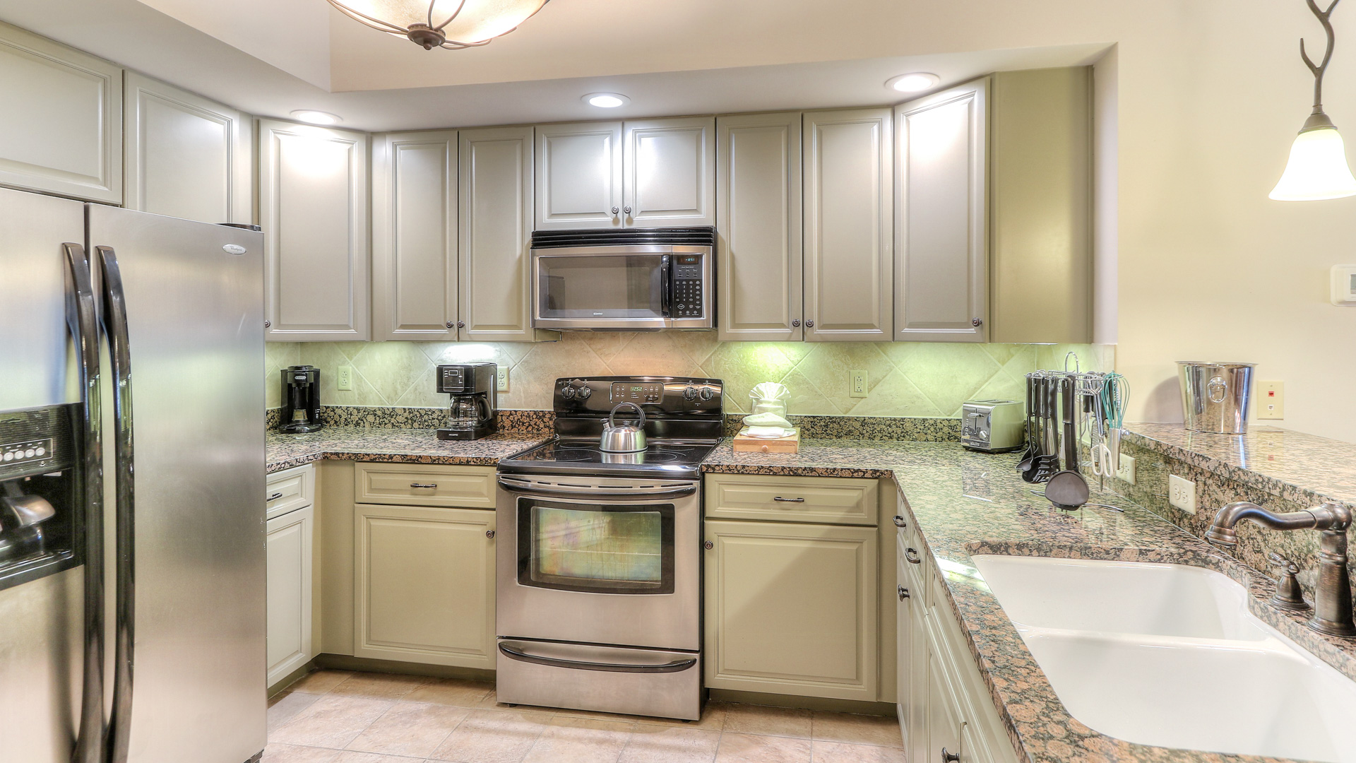 a kitchen with white cabinets and granite counter tops