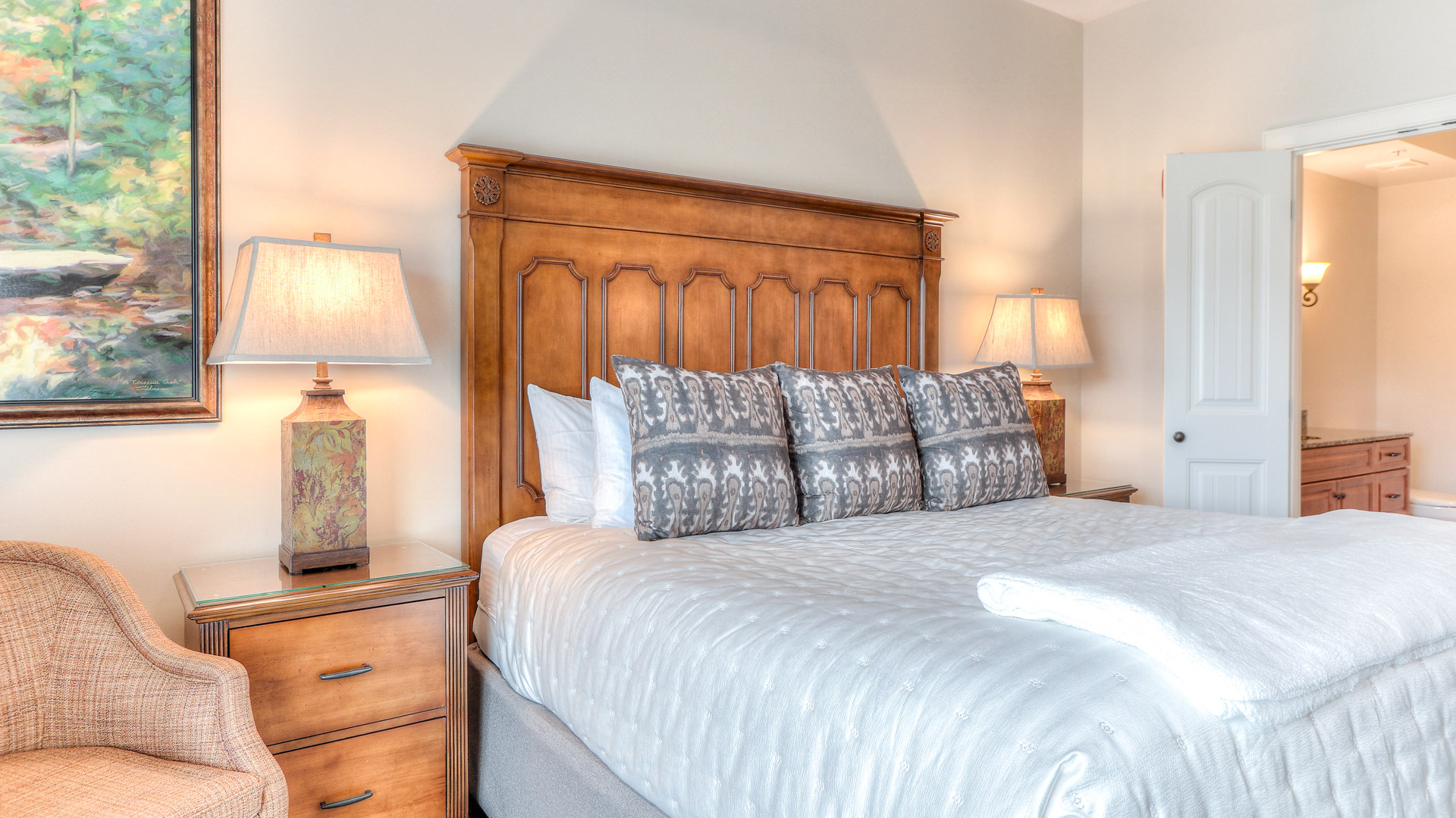 a bed with a wood headboard and lamps