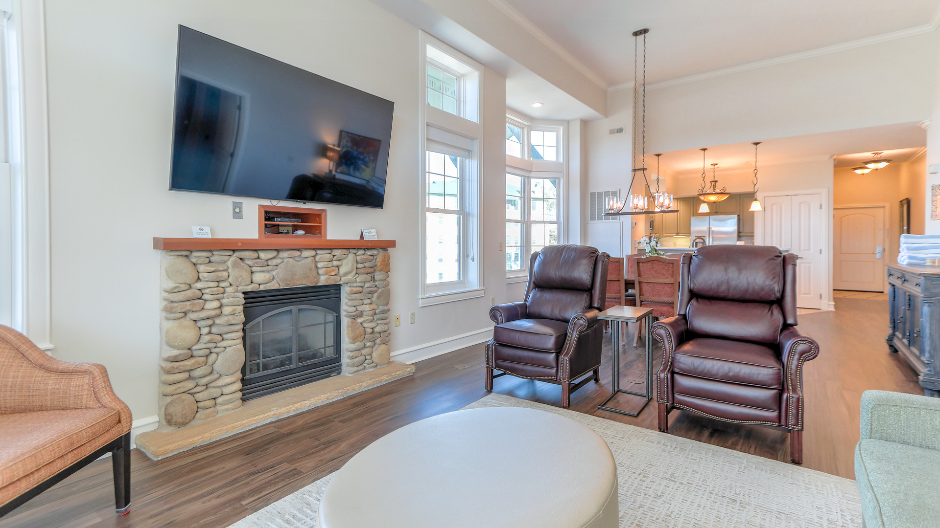 a living room with a fireplace and leather chairs