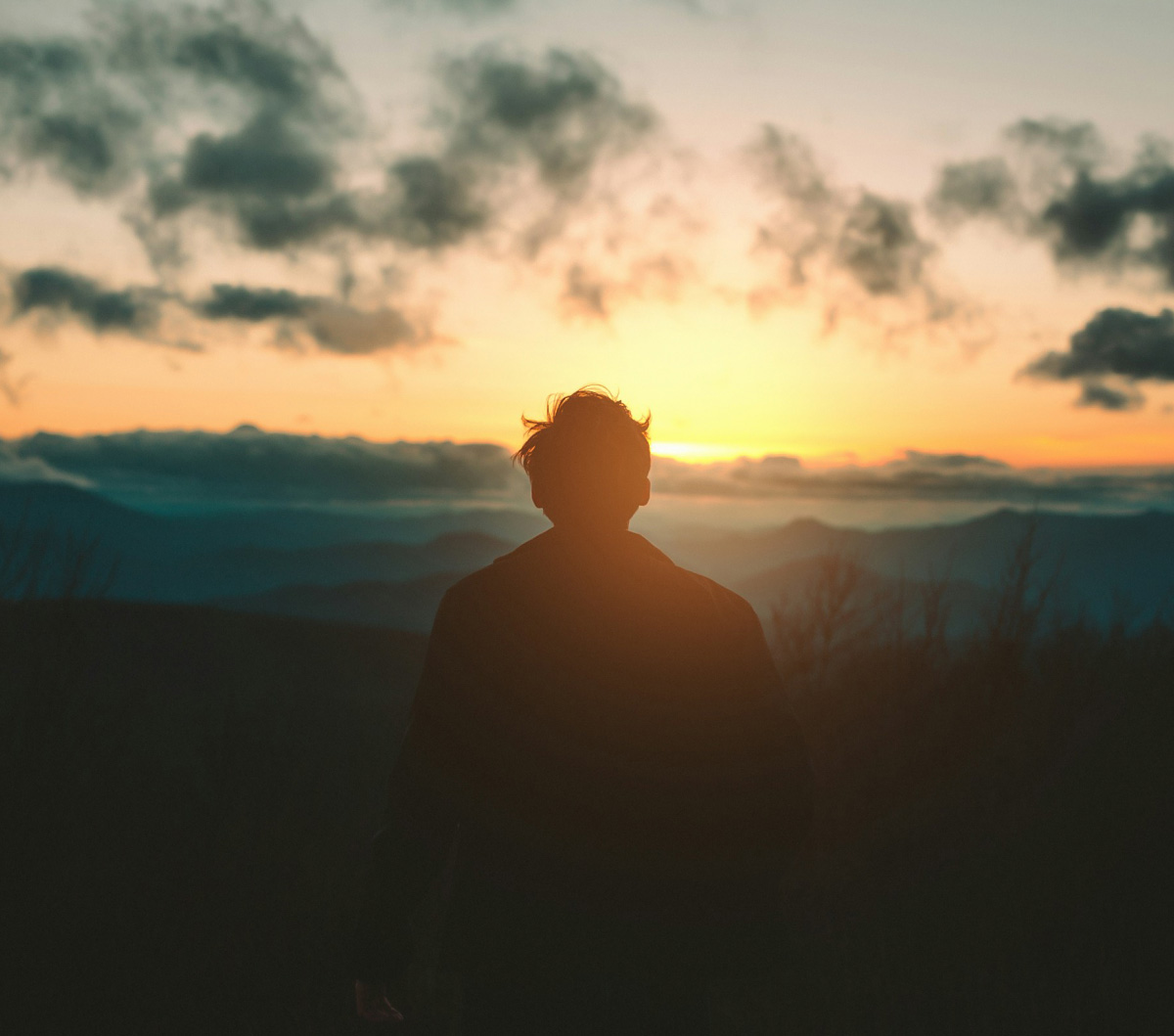 a person standing in front of a sunset
