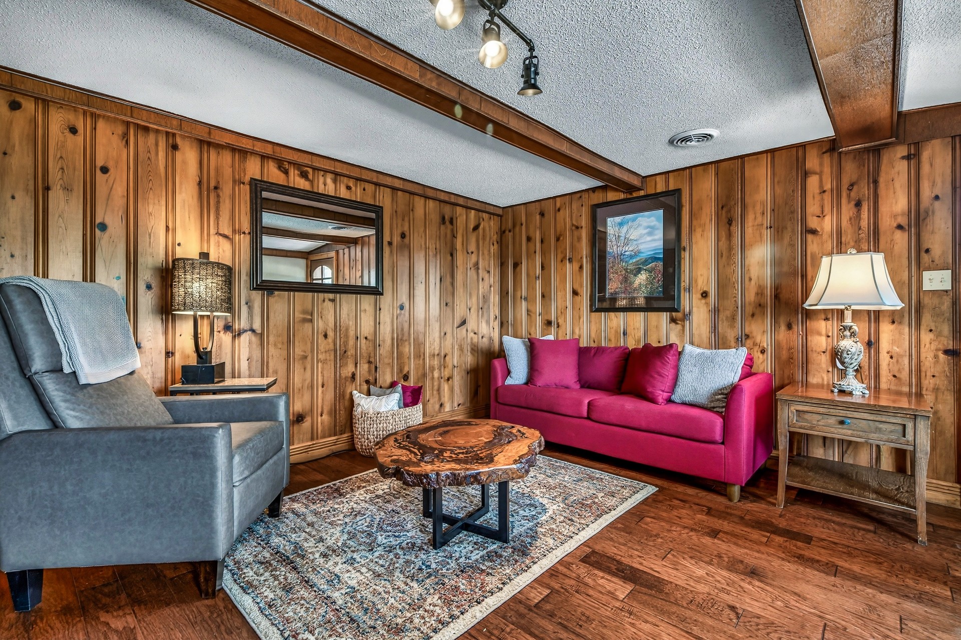 a living room with wood paneling walls and a couch and a table