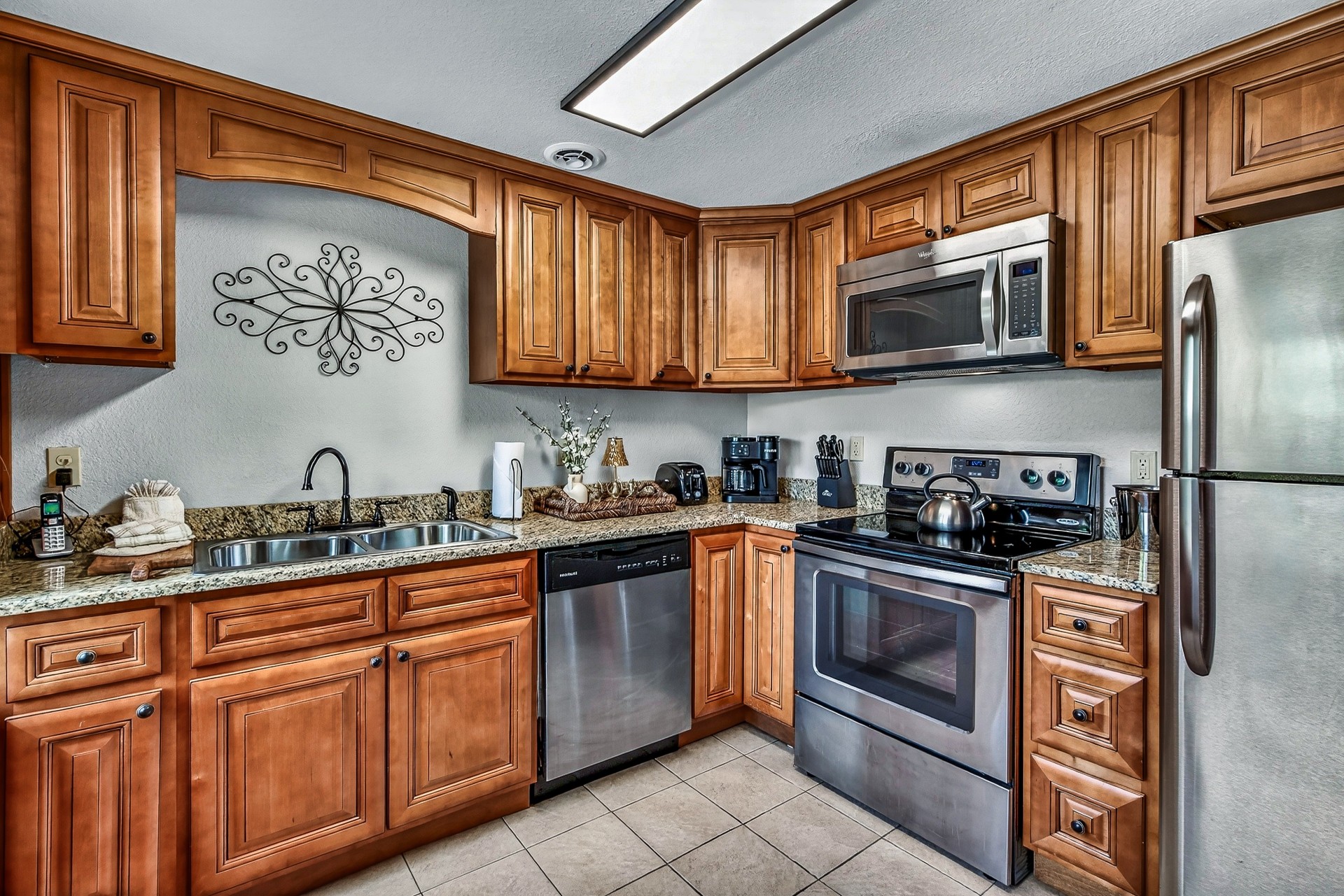 a kitchen with wooden cabinets and granite counter tops