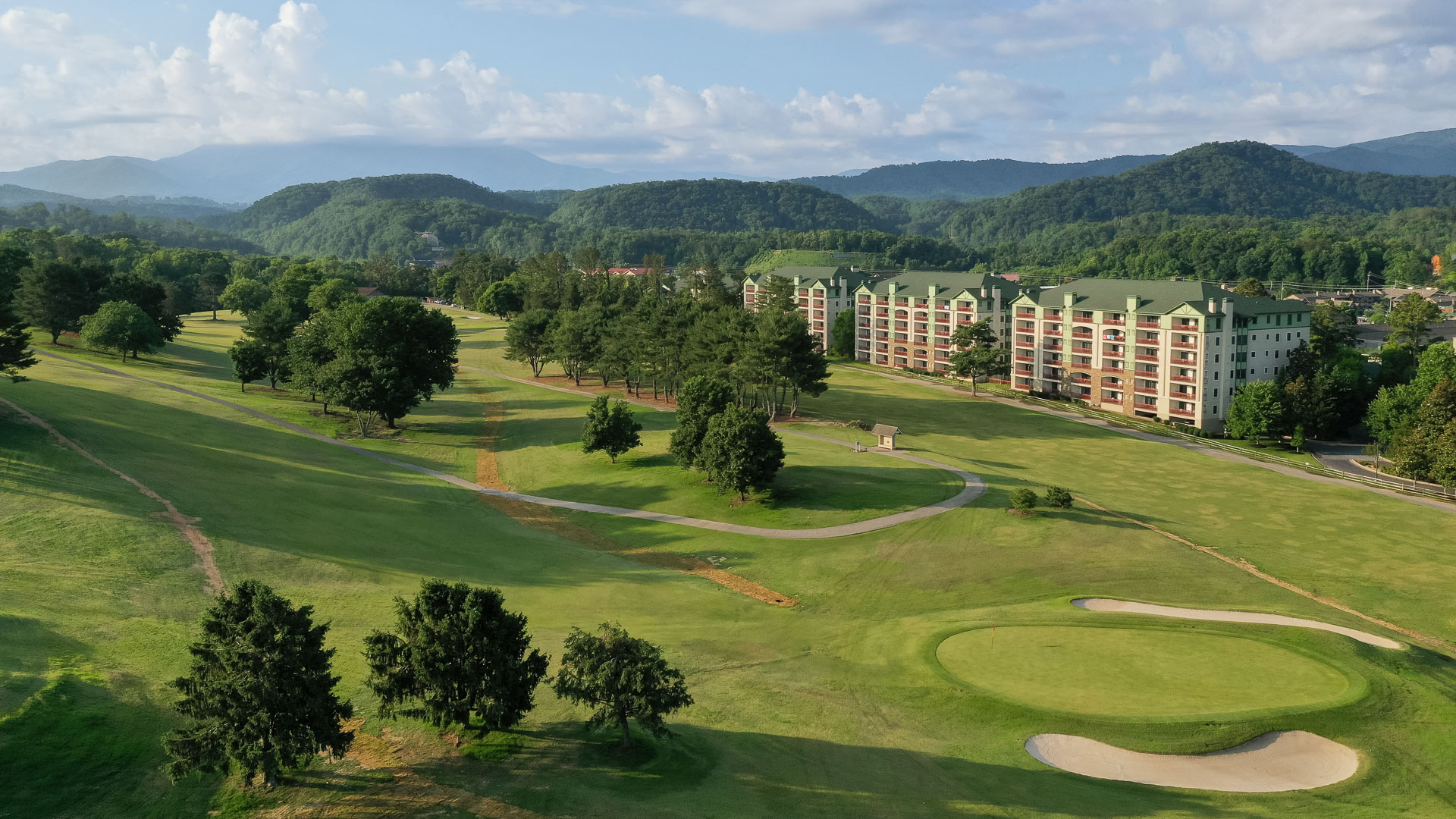 a golf course with trees and buildings