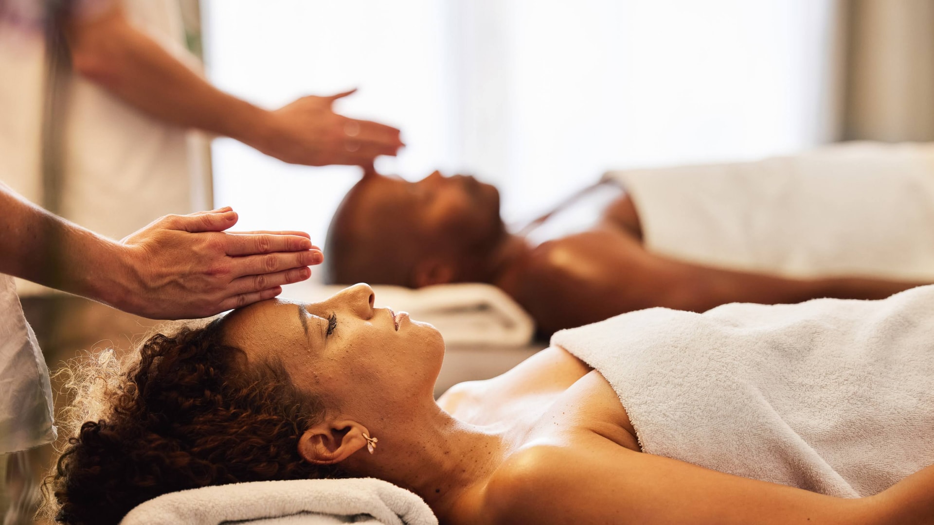 a man and woman lying down on massage beds