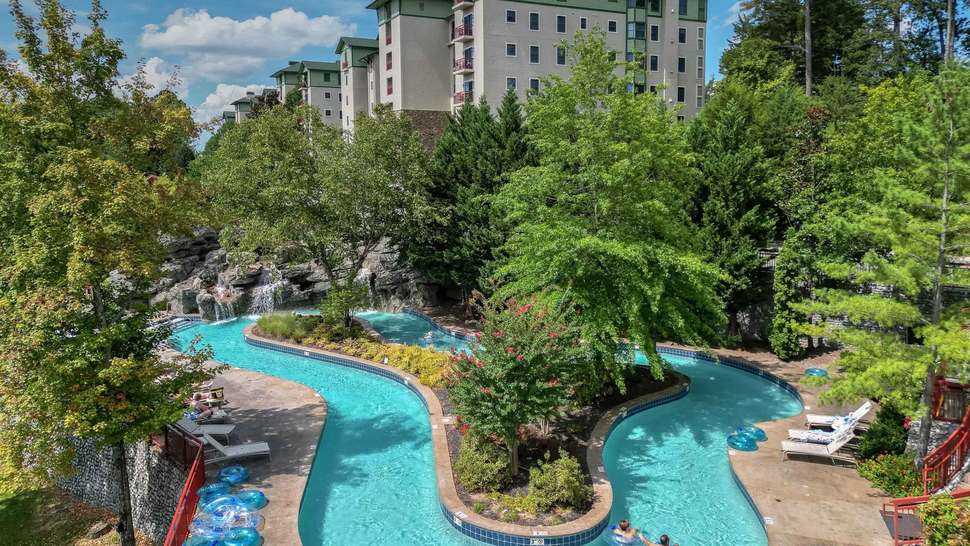 a swimming pool with trees and buildings in the background