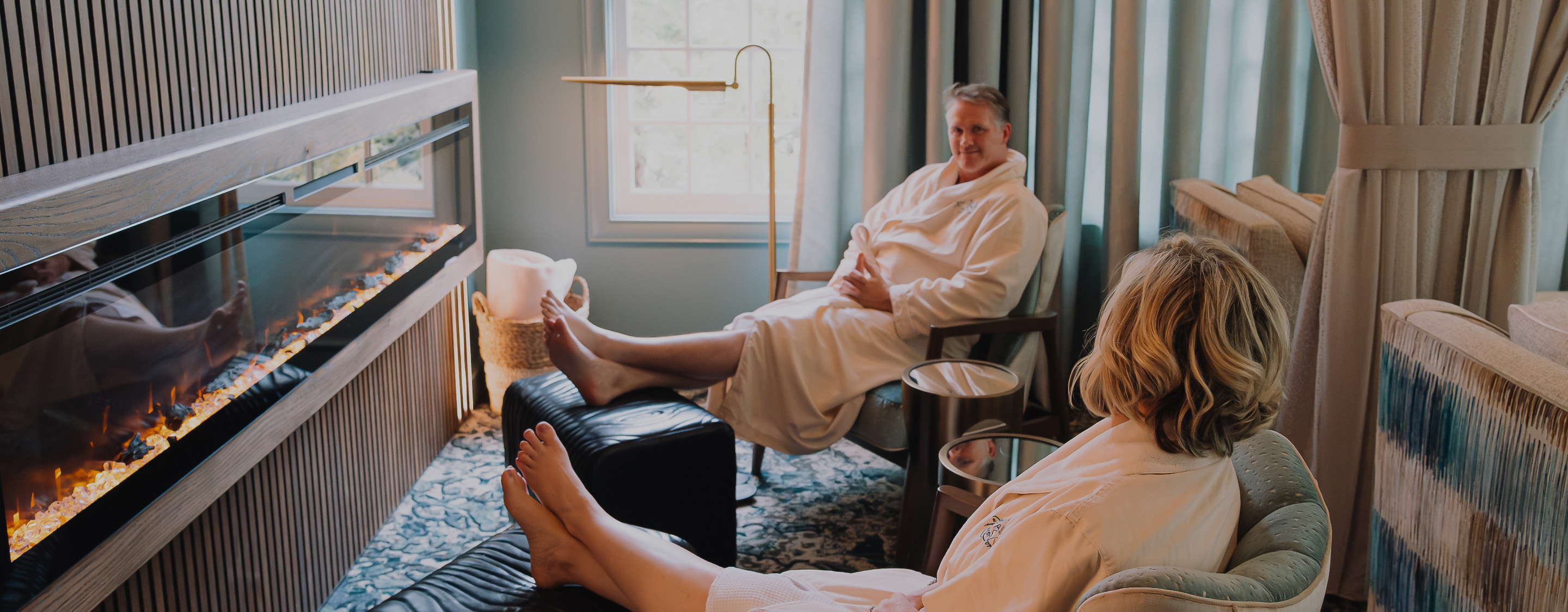 a woman in a white robe sitting in a chair with her feet up