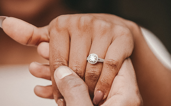 a person putting a diamond ring on a finger