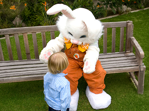 a child looking at a person in a bunny garment