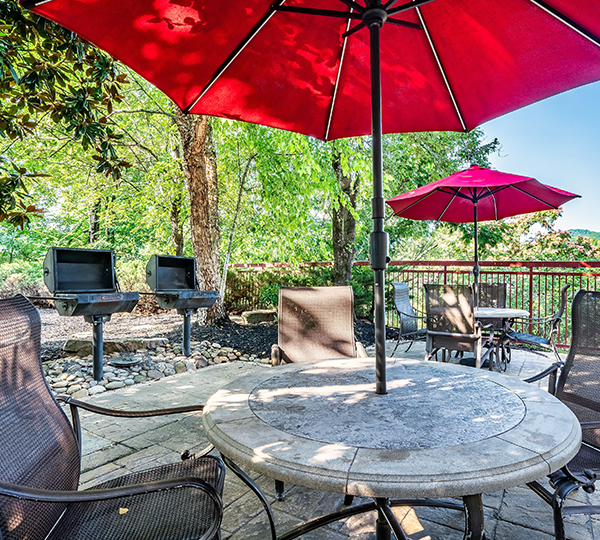 a patio with a table and chairs and a red umbrella