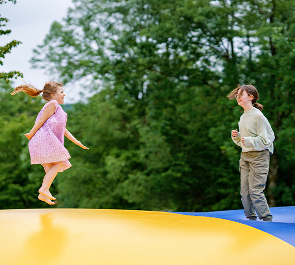 a two children jumping on a trampoline