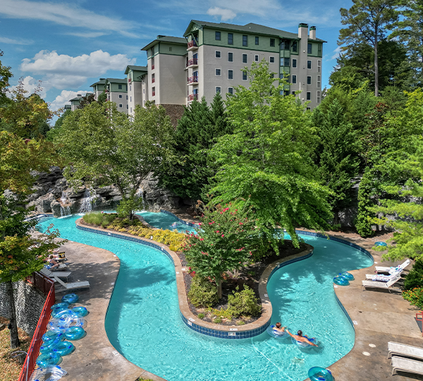 a pool with trees and buildings in the background