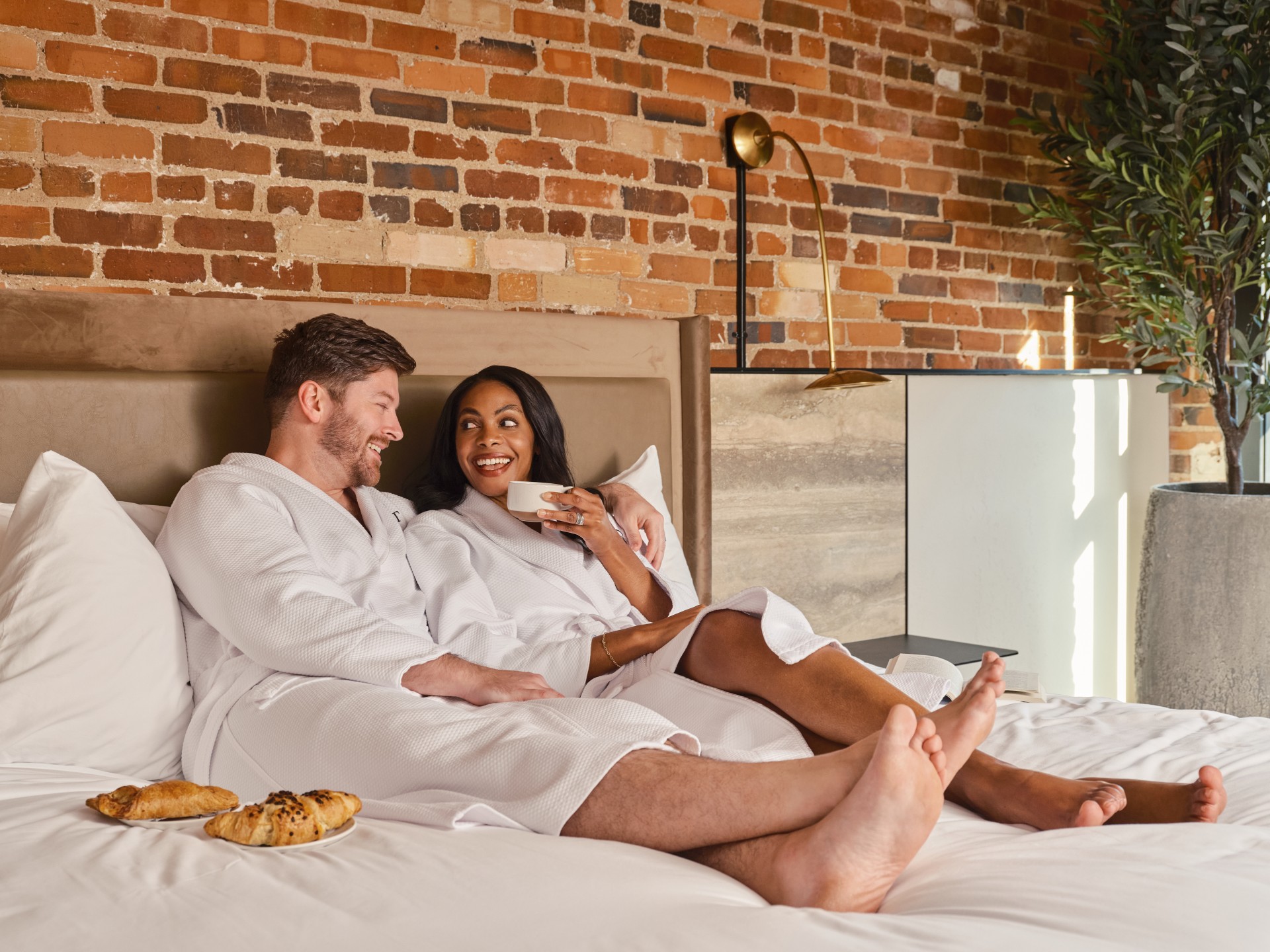 a man and woman in white robes sitting on a bed