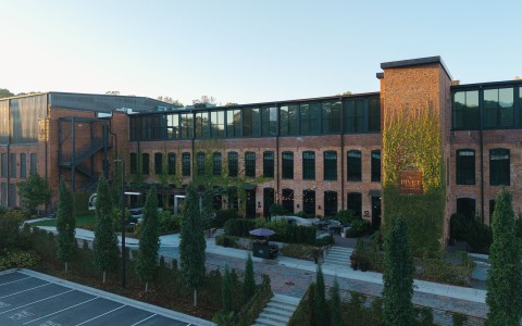 a building with trees and a parking lot