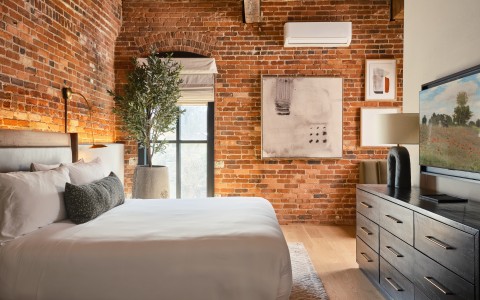 a bedroom with brick walls and a bed