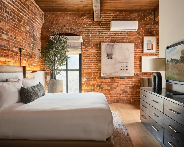 a bedroom with brick walls and a bed