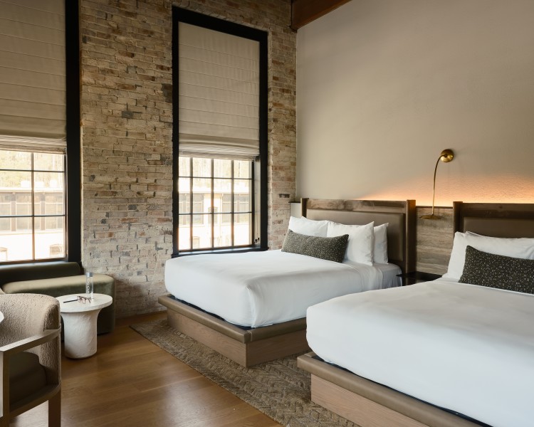 a room with two beds and a brick wall