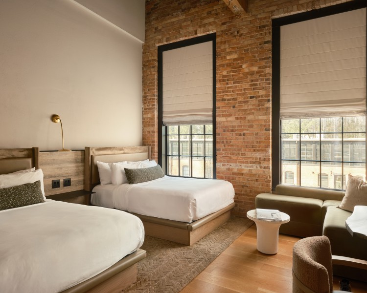a room with two beds and a brick wall