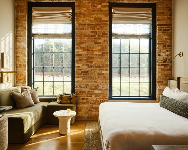 a room with brick walls and a bed and a couch