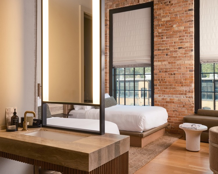 a bathroom with a mirror and a brick wall