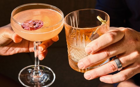 a couple of hands holding drinks