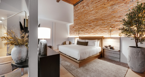 a bedroom with a bed and a brick wall