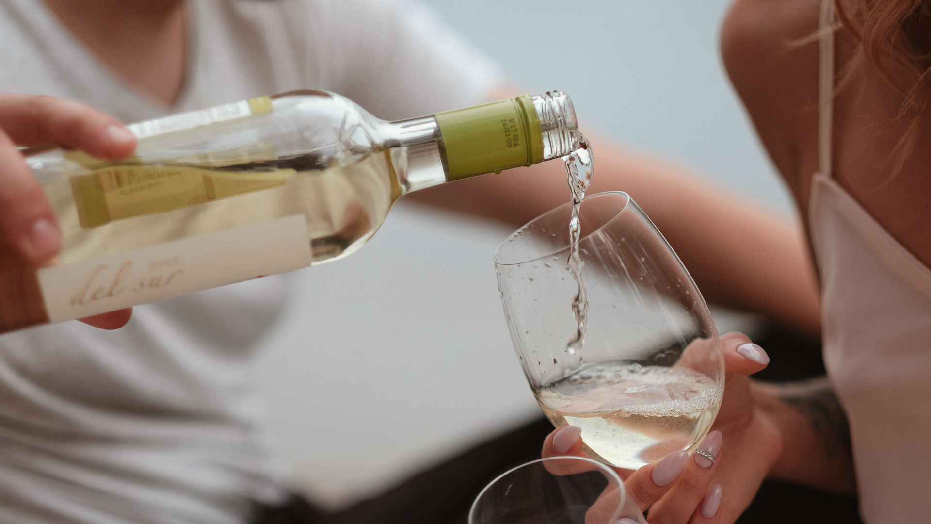 a person pouring wine into a glass