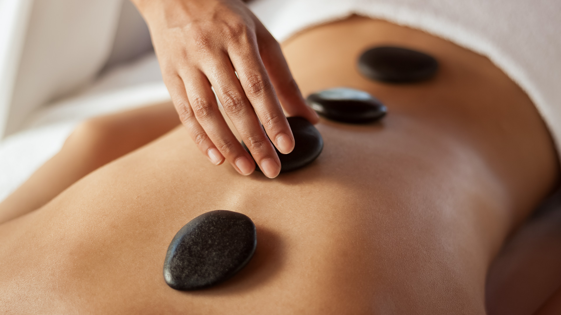 a person getting a hot stone massage