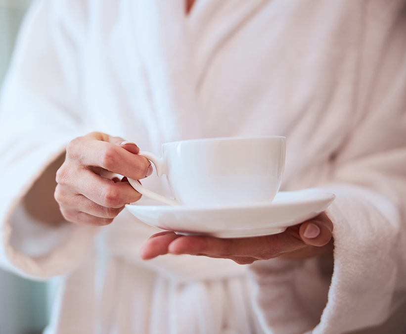 a person holding a cup and saucer