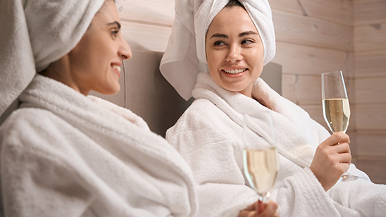 a couple of women wearing white bathrobes and towels