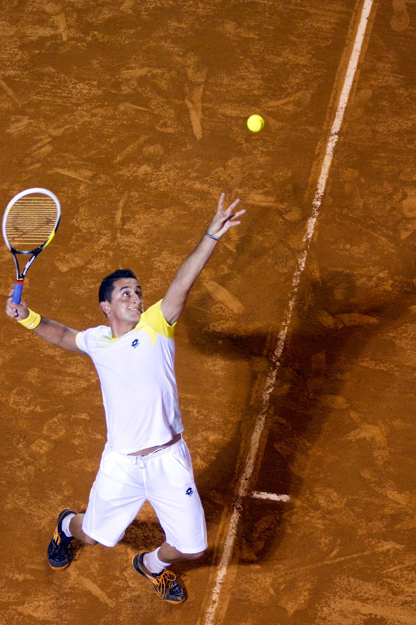 a man playing tennis on a clay court