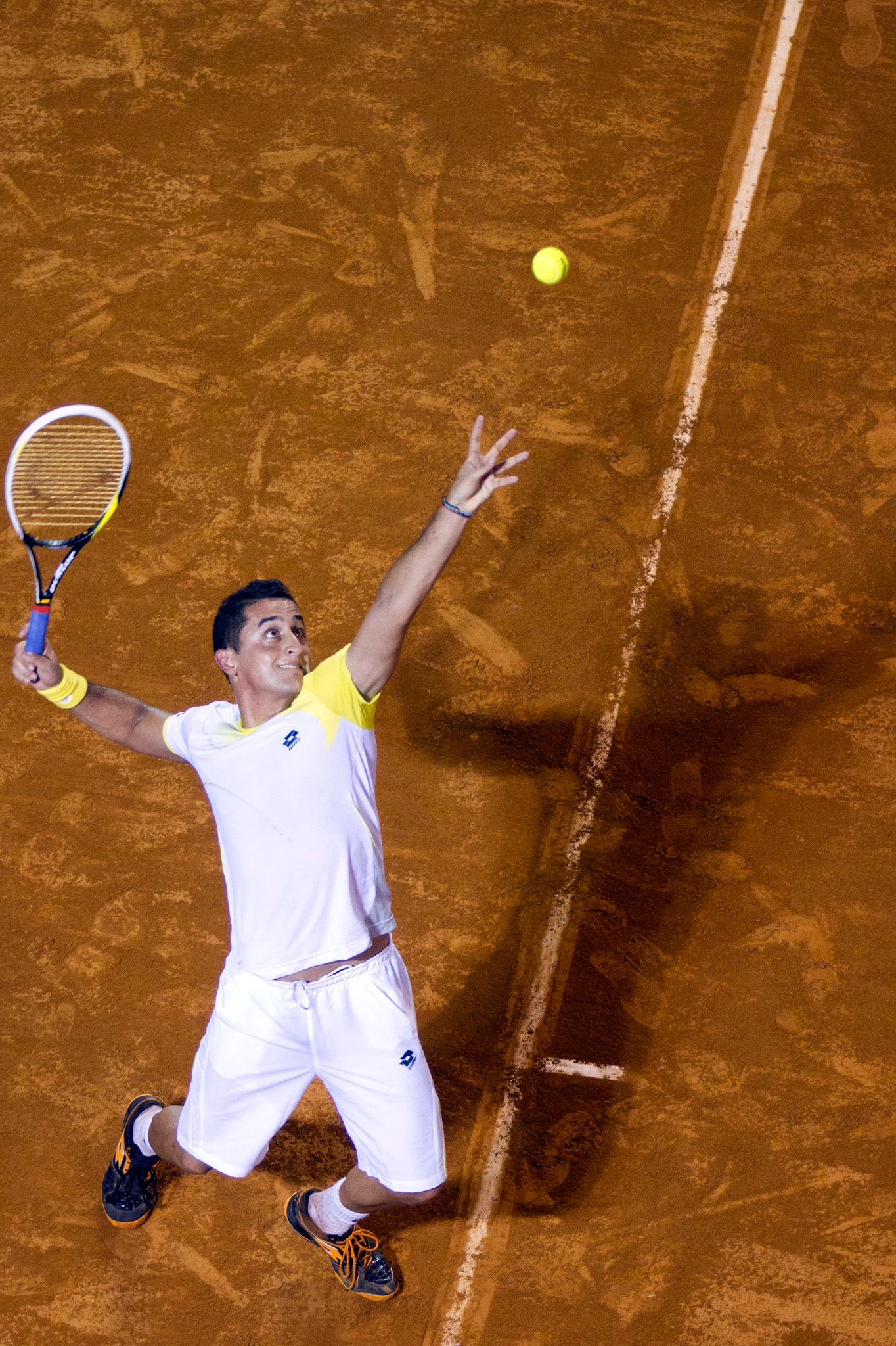 a man playing tennis on a clay court