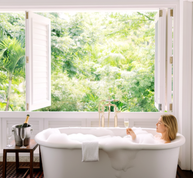 a woman in a bathtub with a champagne bottle and a glass of champagne