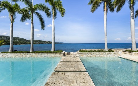 a pool with palm trees and a walkway