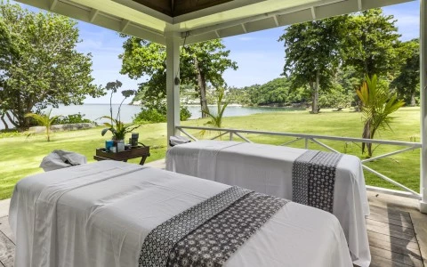 a massage beds outside with a view of the water and trees