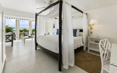 a bedroom with a four poster bed and a rug