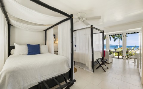 a room with four poster beds and a balcony