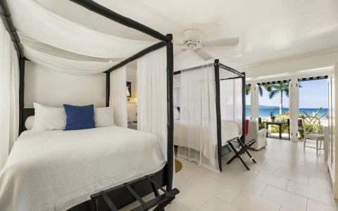 a room with four poster beds and a balcony