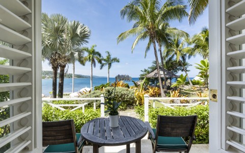 a table and chairs on a deck overlooking a body of water