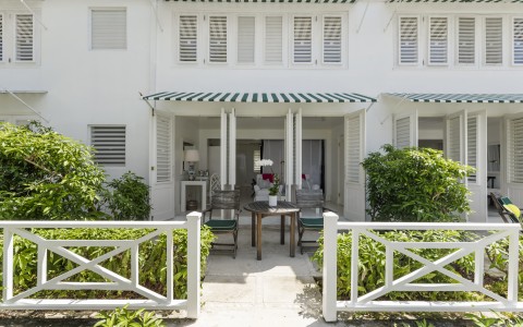 a white building with green and white awnings