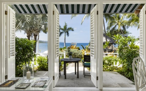 a room with a table and chairs and a view of the ocean