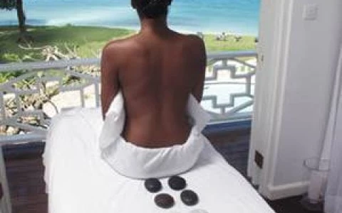 a woman sitting on a bed with stones on it