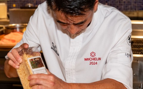 a man in a chef's uniform pouring food into a container